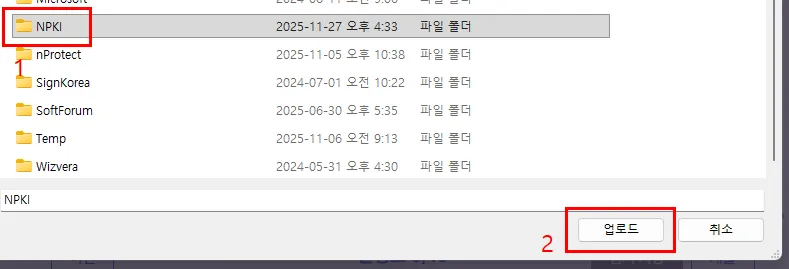 윈도우 폴더 목록에서 NPKI 폴더가 선택돼 빨간 네모와 숫자 1로 표시돼 있고, 오른쪽 아래 업로드 버튼에 숫자 2가 붙어 있다. 목록에는 nProtect, SignKorea, SoftForum, Wizvera 같은 다른 보안 프로그램 폴더도 함께 보인다.